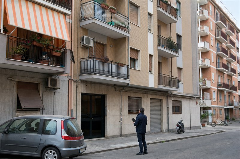 Tecnico osserva un edificio residenziale italiano vissuto